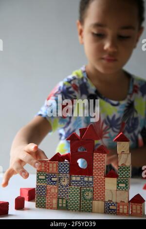 salvador, bahia, brésil - 24 janvier 2021 : un enfant jouant avec un bloc de bois de construction pour enfants dans la ville de Salvador. Banque D'Images