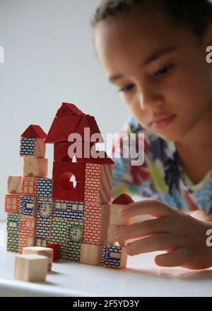 salvador, bahia, brésil - 24 janvier 2021 : un enfant jouant avec un bloc de bois de construction pour enfants dans la ville de Salvador. Banque D'Images