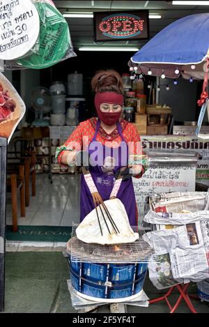 Femme qui cuit le poppadom sur un feu ouvert à une Thaïlande marché alimentaire de rue Banque D'Images