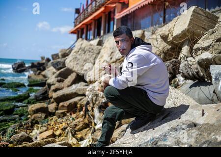 Gaza, Palestine. 27 mars 2021. Un jeune palestinien est assis à la plage de Gaza. Crédit : SOPA Images Limited/Alamy Live News Banque D'Images