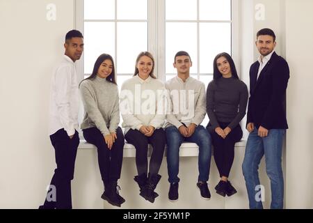 Jeunes étudiants multiethniques, amis ou collègues souriants et regardant l'appareil photo Banque D'Images