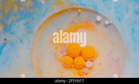 Bulles d'encre mélangées à une substance liquide d'huile, de lait, de savon, de peinture acrylique brillante sur une surface colorée Banque D'Images