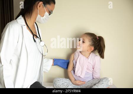 chubby petite fille en examen pédiatrique par son médecin. vacciné par son médecin. Focus sélectif. Vaccin covid bébé Banque D'Images