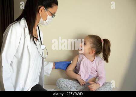 chubby petite fille en examen pédiatrique par son médecin. vacciné par son médecin. Focus sélectif. Vaccin covid bébé Banque D'Images