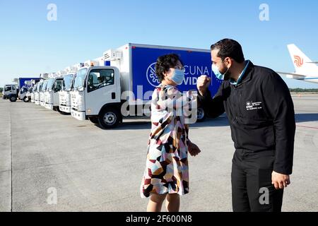 La Paz, El Salvador. 28 mars 2021. L'ambassadeur de la Chine en El Salvador ou Jianhong (L) et le ministre de la Santé d'El Salvador, Francisco Alabi, se touchent à l'aéroport de San Salvador à San Salvador, en El Salvador, le 28 mars 2021. Le Salvador a reçu dimanche le premier lot de vaccins COVID-19 de la société pharmaceutique chinoise Sinovac, qui contribuera à accélérer le processus de vaccination dans le pays, ont indiqué les autorités locales. Crédit: Alexander Pena/Xinhua/Alay Live News Banque D'Images