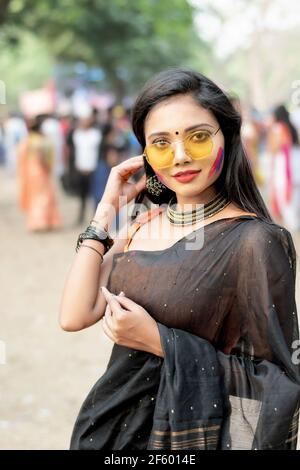 Portrait d'une jeune femme indienne heureuse avec fête de printemps Maquillage célébrant Holi avec des couleurs poudre à Kolkata on Mars 2021 Banque D'Images