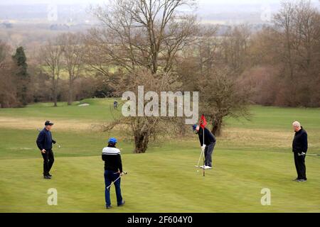 Les golfeurs socialement distancés sur le 6ème green au Club de golf Guildford à Surrey après l'assouplissement du verrouillage de l'Angleterre pour permettre une plus grande liberté en plein air. Date de la photo: Lundi 29 mars 2021. Banque D'Images