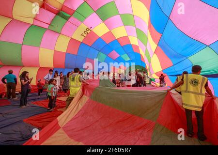 Personnes à l'intérieur de l'enveloppe colorée d'un ballon d'air chaud à moitié gonflé. Ballons au-dessus du Waikato Festival, Hamilton, Nouvelle-Zélande Banque D'Images