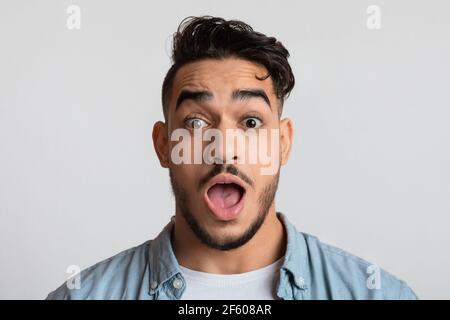 Gros plan portrait d'un jeune arabe choqué regardant l'appareil photo avec étonnement Banque D'Images