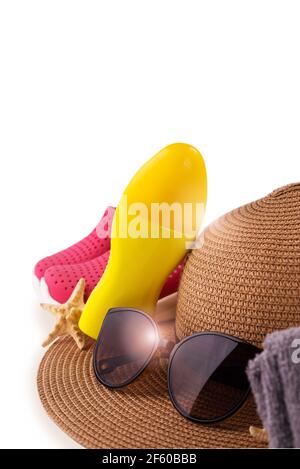 Bouteille de crème solaire vaporisée et chapeau de paille d'été chaussures de plage et lunettes de soleil contre l'espace de copie blanc. Bannière vacances d'été. Banque D'Images