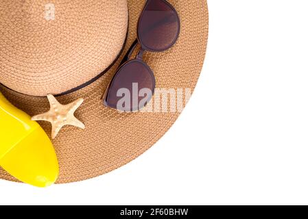 Bouteille de crème solaire vaporisée et chapeau de paille d'été chaussures de plage et lunettes de soleil contre l'espace de copie blanc. Bannière vacances d'été. Banque D'Images