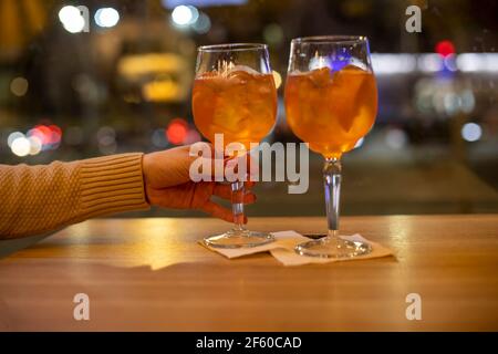 concept de soirée au bar de deux personnes. la main femelle tient le coqueue, un autre coqueue est sur la table. Banque D'Images