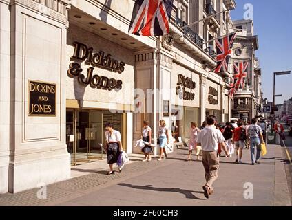 Vue historique de 1988 archives d'une scène ensoleillée de rue d'été Paysage urbain dans le célèbre Regent Street shopping et tourisme destination avec des hommes et des femmes qui marchent le long de la chaussée à l'extérieur Années 1980 façade d'affaires de vente au détail du grand magasin Dickens & Jones et entrée principale avec drapeaux de prise union au-dessus d'un notre mode d'archivage était l'image de la mode de vie des années 80 West End de Londres Angleterre Royaume-Uni Banque D'Images