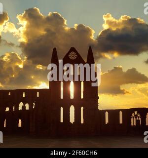 Coucher de soleil historique de 1995 et nuages dans le ciel créant une silhouette et une vue d'archive d'une partie du site côtier des années 1990 Ruines de l'abbaye bénédictine de Whitby, bâtiment classé de catégorie I. Dans le soin du patrimoine anglais une histoire archivistique des années 90 Image dans North Yorkshire Angleterre Royaume-Uni Banque D'Images