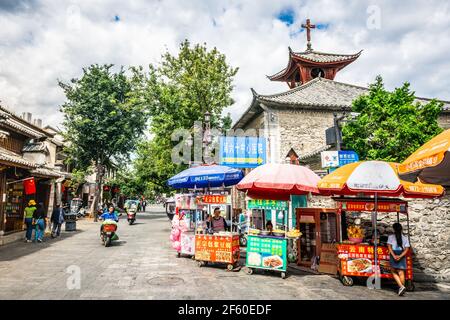 Dali Chine , 5 octobre 2020 : vue sur la rue de la vieille ville de Dali avec stands de nourriture et église catholique de la Trinité dans Dali Yunnan Chine Banque D'Images