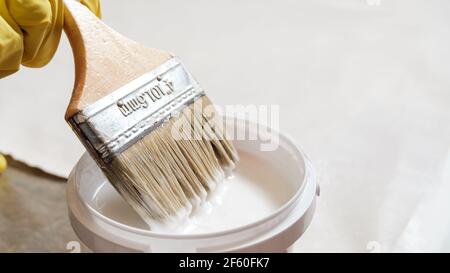 Appliquer de la colle blanche sur le tissu de coton à l'aide d'une brosse Banque D'Images
