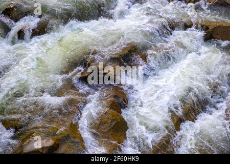 Vue aérienne de la cascade de la rivière avec de l'eau turquoise claire tombant entre des blocs mouillés avec de la mousse blanche épaisse. Banque D'Images