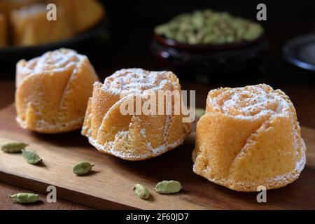 Petits gâteaux de Savoie faits maison fraîchement cuits à la cardamome en forme de rose avec dosettes de cardamome Banque D'Images