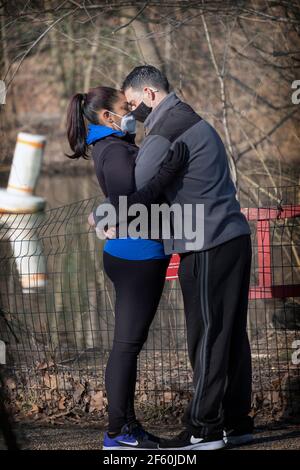 L'AMOUR À L'ÈRE DE LA COVID. Un couple va de la tête à la tête et masque pour se cacher dans un parc à Queens, New York City. Banque D'Images