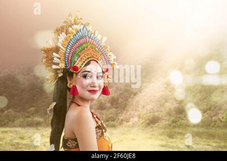 Femme asiatique dansant danse balinaise traditionnelle avec fond de lumière du soleil Banque D'Images