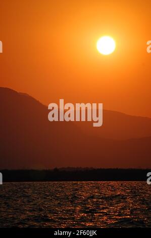 Ciel rouge et orange vif pendant que le soleil se couche Un ciel sans nuages sur la côte turque Banque D'Images