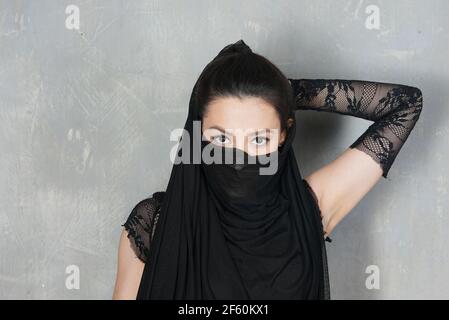 Portrait de femme contre le mur avec la face inférieure du visage recouvert de tissu Banque D'Images