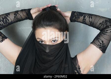 Portrait de femme contre le mur avec la face inférieure du visage recouvert de tissu Banque D'Images