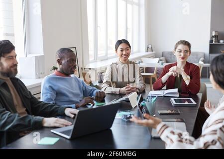Divers groupes de gens d'affaires à table pendant la réunion d'information au bureau, se concentrent sur le sourire femme asiatique partageant des idées Banque D'Images