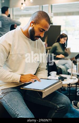 Homme d'affaires utilisant une tablette numérique tout en travaillant avec des collègues dans bureau Banque D'Images