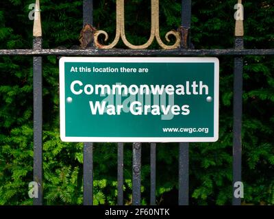 Un panneau vert indique qu'un cimetière est l'emplacement des tombes des hommes et des femmes de service gérés par La Commission des sépultures de guerre du Commonwealth Banque D'Images