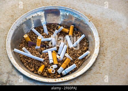 Gros plan sur les mégots de cigarettes dans le cendrier en métal dans la rue. Concept de nombreux débris de cigarettes après avoir fumé. Banque D'Images