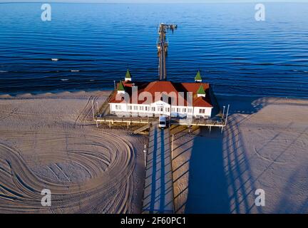 Ahlbeck, Allemagne. 22 mars 2021. La jetée est éclairée sur la plage par le soleil couchant. (Vue aérienne avec un drone) Credit: Jens Büttner/dpa-Zentralbild/ZB/dpa/Alay Live News Banque D'Images