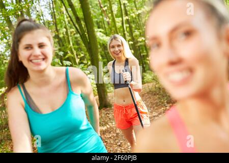 Trois amis faisant marche nordique ensemble dans la nature en été Banque D'Images