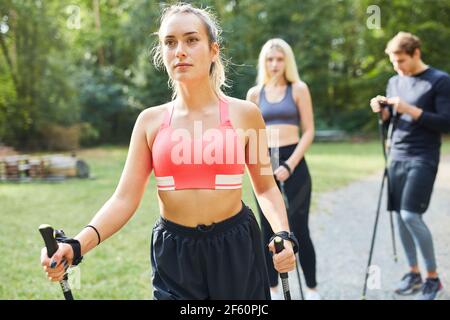 Trois amis faisant Nordic Walking pour la santé dans la nature été Banque D'Images