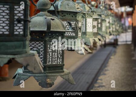 Lanternes japonaises en cuivre ornées suspendues à l'extérieur de Kasuga Taisha ou Grand Sanctuaire un sanctuaire shinto à Nara, Japon Banque D'Images