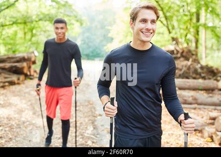 Jeune femme active faisant du sport nordique de marche avec des amis dans la nature Banque D'Images