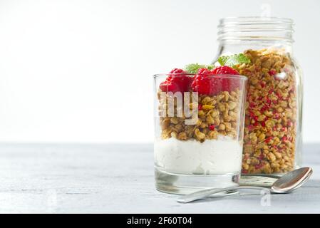 Yaourt avec granola et bleuets et framboises frais, en verre. Petit-déjeuner sain : yaourt à la sauce à la granola et aux baies Banque D'Images