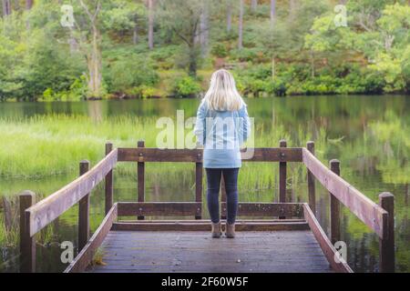 Une jeune touriste féminine seule dans la nature, explore le calme et paisible Glencoe Lochan dans le vert, luxuriant, Scottish Highlands, Ecosse. Banque D'Images