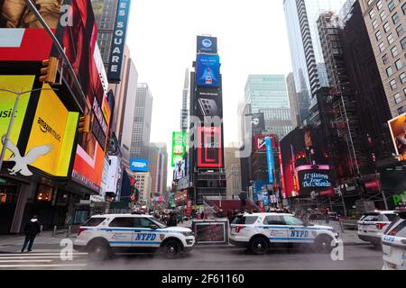 Voitures NYPD garées à Times Square par une journée farade, le célèbre panneau d'affichage numérique Coca Cola est vu en arrière-plan Banque D'Images