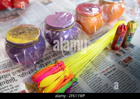 Articles pour célébrer le festival holi comme les couleurs, ballons d'eau, pots en faïence avec des poudres de couleur de fines herbes organiques conservés dans un journal dans une boutique pour Banque D'Images
