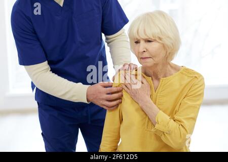 Patient de traitement kinésithérapeute. Le chiropraticien tient la main du patient, le traitement de l'articulation de l'épaule Banque D'Images