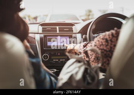 Une femme touche un écran tactile de navigation sur le tableau de bord de la voiture. Banque D'Images