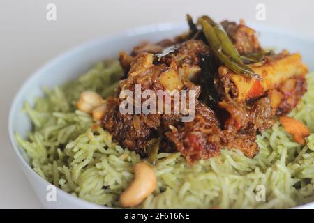 Coriander pulao fait maison, une préparation de riz en une casserole dans le ghee avec des oignons, chutney vert et épices entières. Servi avec du rôti de mouton. Prise de vue sur bac blanc Banque D'Images