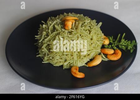 Coriander pulao fait maison, une préparation de riz en une casserole dans le ghee avec des oignons, chutney vert et épices entières. Prise de vue sur fond blanc Banque D'Images