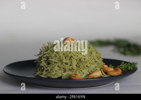 Coriander pulao fait maison, une préparation de riz en une casserole dans le ghee avec des oignons, chutney vert et épices entières. Prise de vue sur fond blanc Banque D'Images