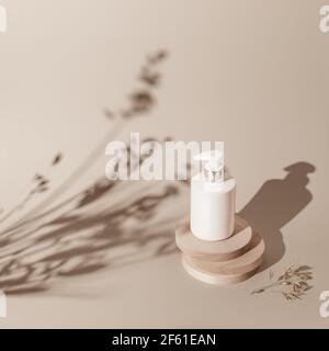 Le concept de produits naturels, de soins de la peau et de cosmétiques à base d'ingrédients écologiques. Composition d'une bouteille cosmétique sur un podium naturel sur un lig Banque D'Images