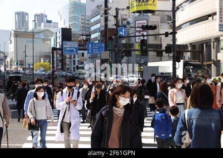 Tokyo, Japon. 24 mars 2021. Des piétons portant des masques de protection contre Covid-19 traversent une rue très fréquentée à Shinjuku, Tokyo. Crédit : SOPA Images Limited/Alamy Live News Banque D'Images