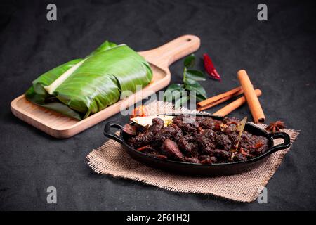 Rôti de boeuf ou pothu ulartheyadu, plat spécial kerala disposé dans une table noire et en feuille de banane de manière traditionnelle placée sur une couleur noire Banque D'Images