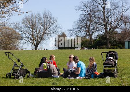 Londres, Royaume-Uni, 29 mars 2021 : à Brockwell Park, dans le sud de Londres, les gens ont profité du temps ensoleillé le premier jour de l'assouplissement du confinement en Angleterre. Certaines personnes s'exerçaient et d'autres piquées en petits groupes. Pour les parents de petits enfants, la possibilité de contacts sociaux est essentielle à leur santé mentale et au développement de leurs enfants. Anna Watson/Alay Live News Banque D'Images