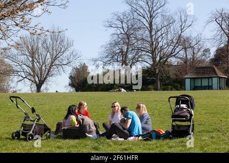 Londres, Royaume-Uni, 29 mars 2021 : à Brockwell Park, dans le sud de Londres, les gens ont profité du temps ensoleillé le premier jour de l'assouplissement du confinement en Angleterre. Certaines personnes s'exerçaient et d'autres piquées en petits groupes. Pour les parents de petits enfants, la possibilité de contacts sociaux est essentielle à leur santé mentale et au développement de leurs enfants. Anna Watson/Alay Live News Banque D'Images